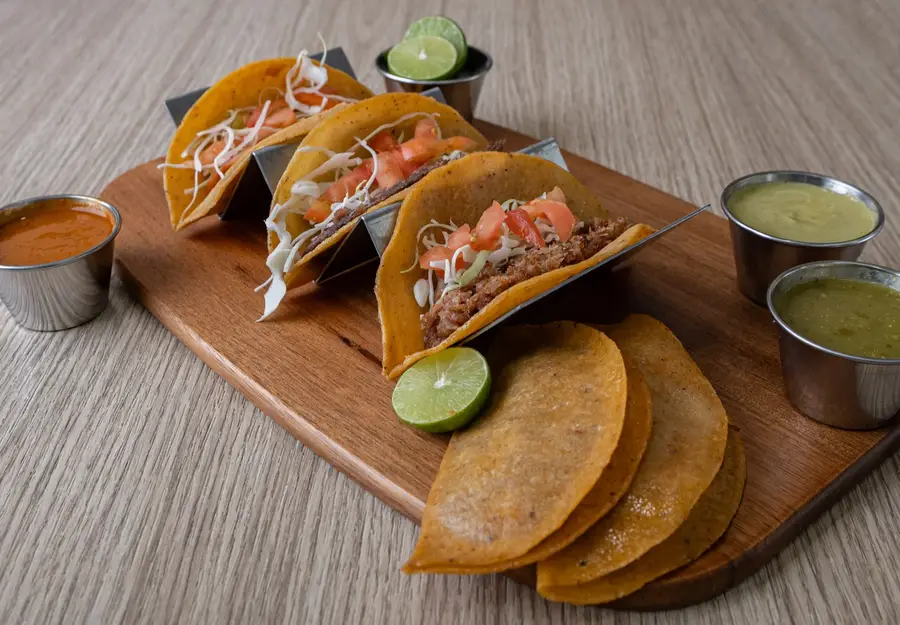 Tacos de vapor surtidos con repollo, tomate, limón y salsas
